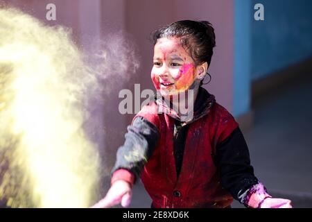 Piccola ragazza che gioca con i colori holi concetto. Foto Stock