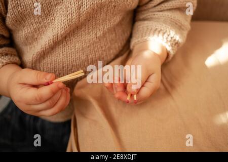 Il bambino gioca con Lucifer match, pericolo in casa. Un bambino piccolo può mettere un fuoco, partite i bambini non sono un giocattolo. È molto pericoloso giocare con il wi Foto Stock