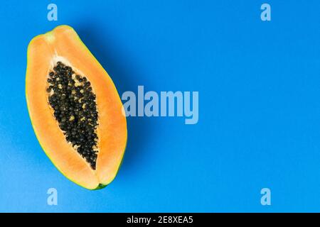 Mezzo papaya su sfondo blu. Spazio di copia. Vista dall'alto. Foto Stock