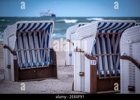 11 maggio 2020, Meclemburgo-Pomerania occidentale, Rostock: Sedie da spiaggia vuote di un'azienda di noleggio stand sulla spiaggia di Warnemünde. Dopo aver rinnovato le ricerche di Corona, i mobili da spiaggia possono ora essere affittati a vacanzieri e bagnanti di nuovo. A causa del clima freddo e tempestoso, con temperature intorno agli otto gradi, tuttavia, non c'erano quasi visitatori sulla costa baltica. Foto: Jens Büttner/dpa-Zentralbild/ZB Foto Stock