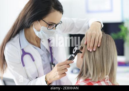 Otorhinolaringologo che esamina i pazienti irritati all'orecchio con otoscopio in clinica Foto Stock