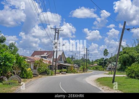 Strada di campagna che si snoda attraverso il villaggio di Groningen nel distretto di Saramacca, Suriname / Surinam Foto Stock
