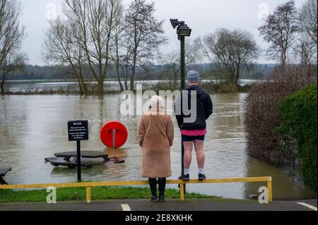 Wargrave, Berkshire, Regno Unito. 1 febbraio 2021. Una coppia guarda la forza della corrente sul Tamigi mentre esplode le sue rive a Wargrave. Un avvertimento di alluvione rimane in vigore per il Tamigi a Wargrave ed è prevista un'inondazione di proprietà. Questa settimana è prevista un'ulteriore pioggia. Le inondazioni stanno diventando un evento più regolare nel Regno Unito, poiché rimaniamo in un'emergenza climatica. Credit: Maureen McLean/Alamy Live News Foto Stock