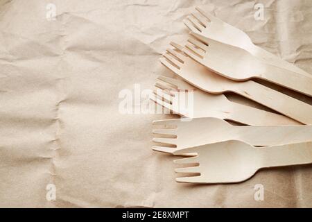 utensili da cucina monouso eco-compatibili su sfondo cartaceo. vista dall'alto. forcelle in legno. concetto eco-compatibile Foto Stock