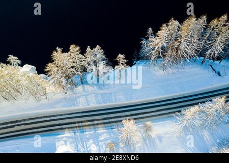 Strada vuota coperta di neve sulle rive del lago ghiacciato Sils dall'alto, Cantone di Graubunden, Engadin, Svizzera Foto Stock