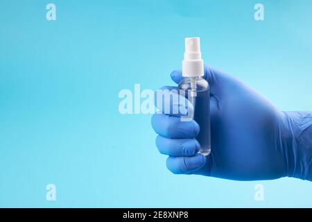 persona medica con guanti di protezione blu con protezione igienizzante personale su sfondo blu. spazio per la copia. Foto Stock