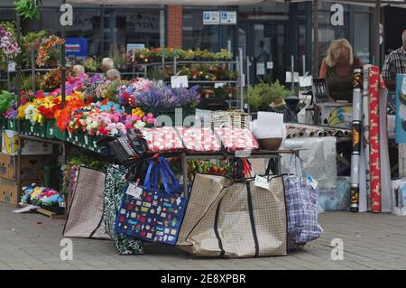 Una bancarella di fiori e proprietario ad un mercato aperto dello shopping Foto Stock