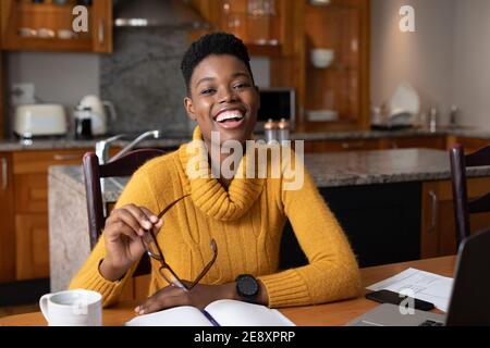 Ritratto di donna afroamericana sorridente mentre lavora da casa Foto Stock