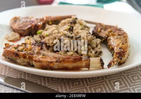 Costoletta di agnello marinata alla griglia con risotto di funghi cheesy Foto Stock