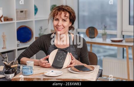 Donna che mostra piatto finito con disegno Foto Stock