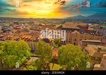 Cielo drammatico e tempestoso con i colori del tramonto sulla città storica di Ginevra. Panorama cittadino dello skyline di Ginevra, francese-svizzero in Svizzera. Vista aerea dei tetti e. Foto Stock