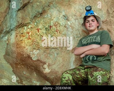 Giovane esploratore alla ricerca di dipinti rupestri Foto Stock