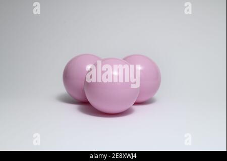 Closeup di tre palline di plastica viola isolate su un bianco sfondo Foto Stock
