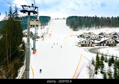 Bukovel, Ucraina 3 febbraio 2019: Complessi alberghieri sullo sfondo di pittoreschi Carpazi invernali, turisti a Bukovel, Ucraina. 2019 Foto Stock