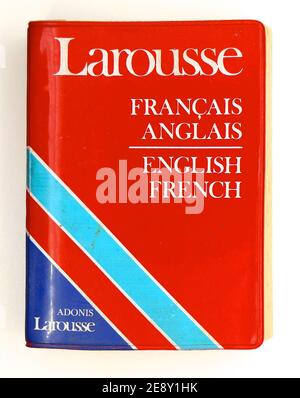 Foto di un vecchio dizionario usato Larousee Francese Inglese con una copertina di plastica rossa bianca e blu su sfondo bianco Foto Stock