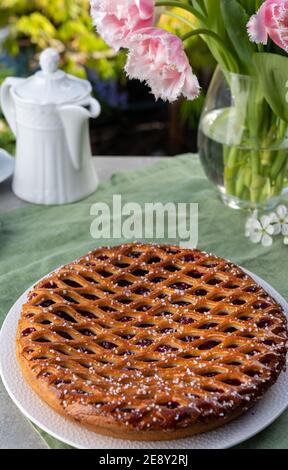 Torta di ciliegie con graticcio di Limburgo, Olanda, servita in giardino soleggiato Foto Stock