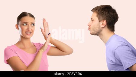 L'uomo che cerca di baciare la donna disgustata che lo respinge Foto Stock