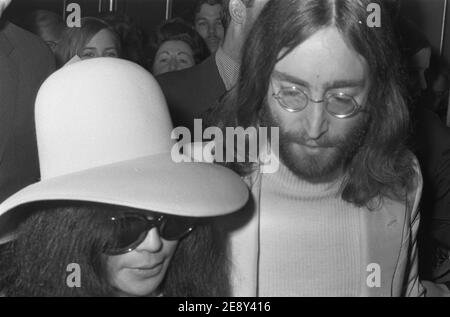 John Lennon e Yoko Ono con guardie del corpo dopo due settimane di Bed-ins for Peace all'Hilton Hotel di Amsterdam, 1969. Foto Stock