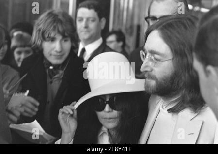 John Lennon e Yoko Ono con guardie del corpo dopo due settimane di Bed-ins for Peace all'Hilton Hotel di Amsterdam, 1969. Foto Stock