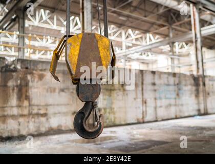 Gancio per gru a puleggia di sollevamento isolato giallo per impieghi pesanti in applicazioni industriali fabbrica di utensili tecnici con cavi e clip di sicurezza Foto Stock