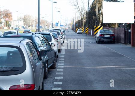 Una fredda mattina d'autunno su una strada cittadina e le auto parcheggiate di fila. Le auto sono parcheggiate nei sobborghi Foto Stock