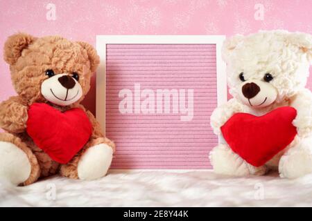 Happy Valentine's Day Bears with Pink Letterboard notifica messaggio, e rose rosse, su uno sfondo di pelliccia rosa e bianco. Foto Stock