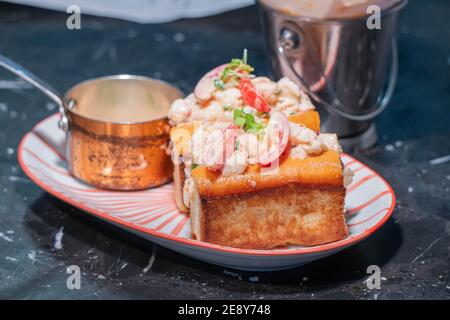 Aragosta Roll.fresh Maine Lobster bollito, mescolato con mayo, sedano, erba cipollina servita in rotolo di eroe tostato con lattuga croccante e burro tirato. Foto Stock