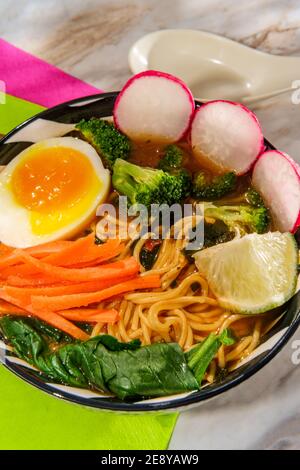 Ramen vegetale coreano speziato guarnito con verdure e un morbido uovo bollito Foto Stock