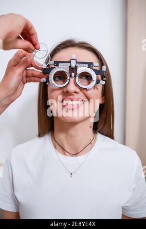 Giovane bella donna all'appuntamento dell'oftalmologo controlla la sua vista. Il medico oftalmologo esamina il paziente Foto Stock