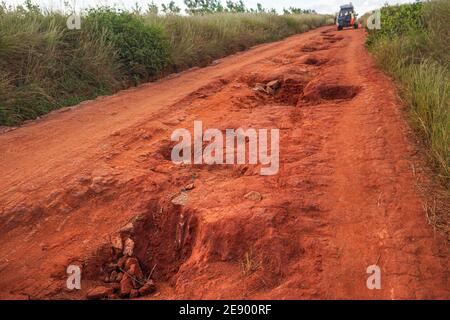 Polvere rossa e fango su strada in cattive condizioni con grandi buchi e protuberanze che si formano dopo la pioggia. I percorsi per il parco nazionale di Andringitra sono estremamente cattivi durante il bagnato Foto Stock