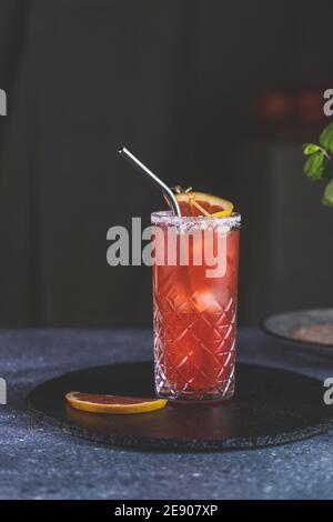 Pompelmo rosa Mezcal Paloma cocktail in calice con gocce d'acqua sul tavolo in vera casa. Nuovo concetto di vita della quarantena. Primo piano, dep. Bassa Foto Stock