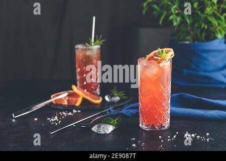 Pompelmo rosa Mezcal Paloma cocktail in calice con gocce d'acqua sul tavolo in vera casa. Nuovo concetto di vita della quarantena. Primo piano, dep. Bassa Foto Stock