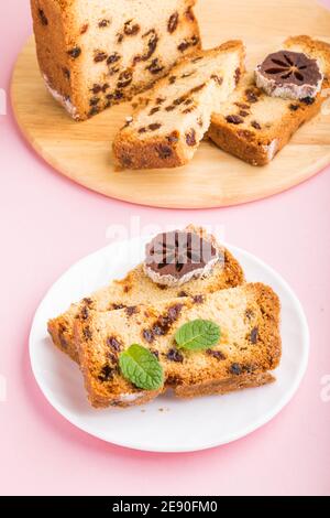 Torta fatta in casa con uvetta e persimmon secco su sfondo rosa pastello. Vista laterale, primo piano, spazio di copia. Foto Stock