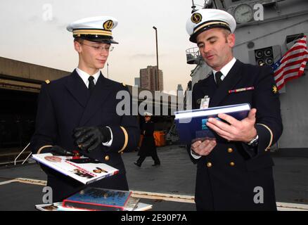 (L-R) Ensign Bastieu Stroh e Senior Petty Officer Nicolas Gandon distribuiscono libri a bordo della portaerei francese Jeanne d'Arc dopo l'attracco nel porto di New York al molo 92 a New York City, USA il 28 dicembre 2007. La nave da guerra francese, che funge da nave di addestramento per gli ostriani della marina francese, ha trasportato oltre 10,000 libri francesi che saranno offerti ai bambini che partecipano ai nuovi programmi francesi-inglesi di New York e alle scuole di New Orleans devastate dall'hurrican Katrina. Foto di Gregorio Binuya/ABACAPRESS.COM Foto Stock