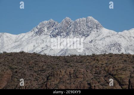 Una tempesta invernale copre le quattro montagne sulla neve nella natura selvaggia del deserto dell'Arizona fuori dalla città di Phoenix. Foto Stock