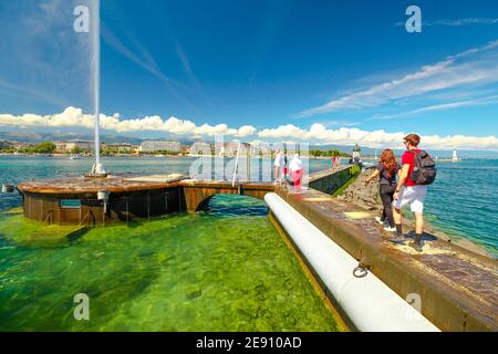 Ginevra, Svizzera - 15 agosto 2020: Fontana Jet d'eau, simbolo di Ginevra nel lago Leman. I turisti e la gente di lifestyle su un molo visitano il turista famoso Foto Stock
