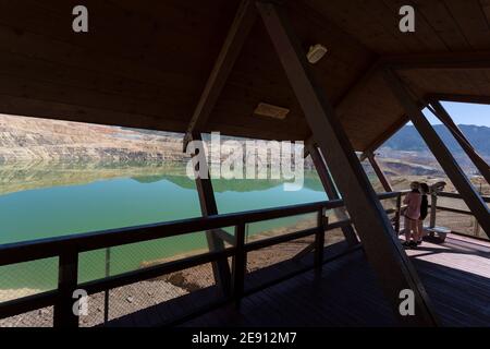 I visitatori osservano il Berkeley Pit da una piattaforma di osservazione a Butte, Montana. L'ex miniera di rame a cielo aperto, ora riempita di acqua fortemente acida wh Foto Stock