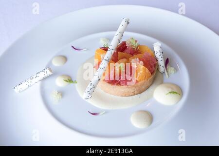 Colorato dessert gourmet di crostata di agrumi con bastoncini di cioccolato bianco Foto Stock