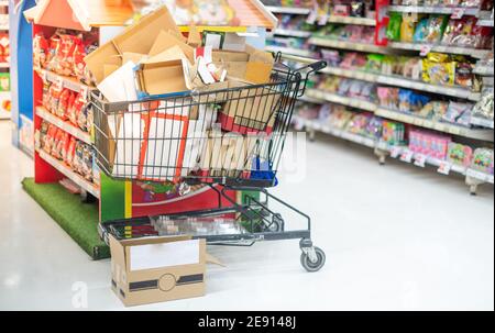 Effetto sfocato nella corsia Supermarket con carrello nero e argento, Shopper scegliere il cibo nel supermercato Panic acquirente per l'accumulo di foo Foto Stock