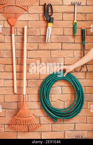 Mano femminile con attrezzi da giardinaggio in fienile Foto Stock