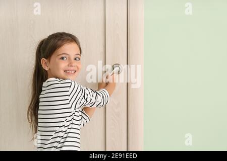 Carino bambina che apre la porta Foto Stock