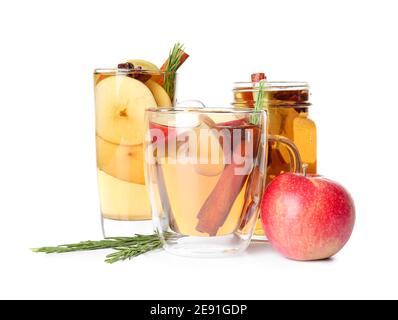 Bevanda gustosa con spezie e fette di mela in tazze sopra sfondo bianco Foto Stock