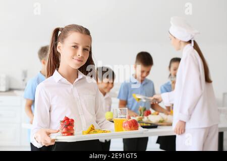 Studentessa che pranza nella mensa scolastica Foto Stock