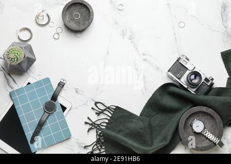 Composizione elegante con orologio da polso, fotocamera e sciarpa su sfondo chiaro Foto Stock