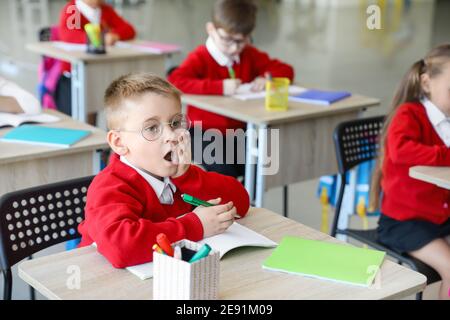 Scolaro sorpreso durante la lezione in classe Foto Stock