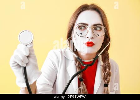 Pantomimista femminile vestita come medico su sfondo colorato Foto Stock