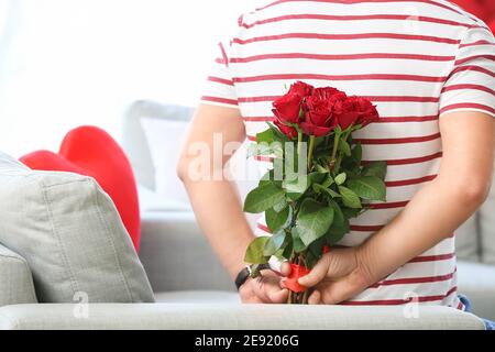 Uomo maturo con bouquet di fiori per sua moglie a. a casa il giorno di San Valentino Foto Stock