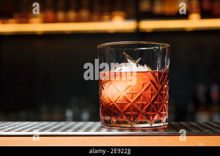 Whisky con una palla di ghiaccio in un bicchiere. Pronto a mangiare. Foto Stock