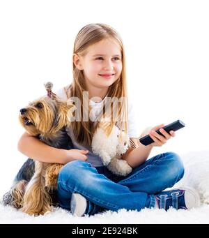 Carina ragazza e il suo cane che cambia canali con il telecomando tv isolato su bianco Foto Stock