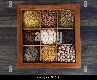 Vista dall'alto delle noci e delle spezie in un cucchiaio su un tavolo di legno Foto Stock